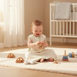Bébé heureux portant la barboteuse en coton bio dans une chambre lumineuse